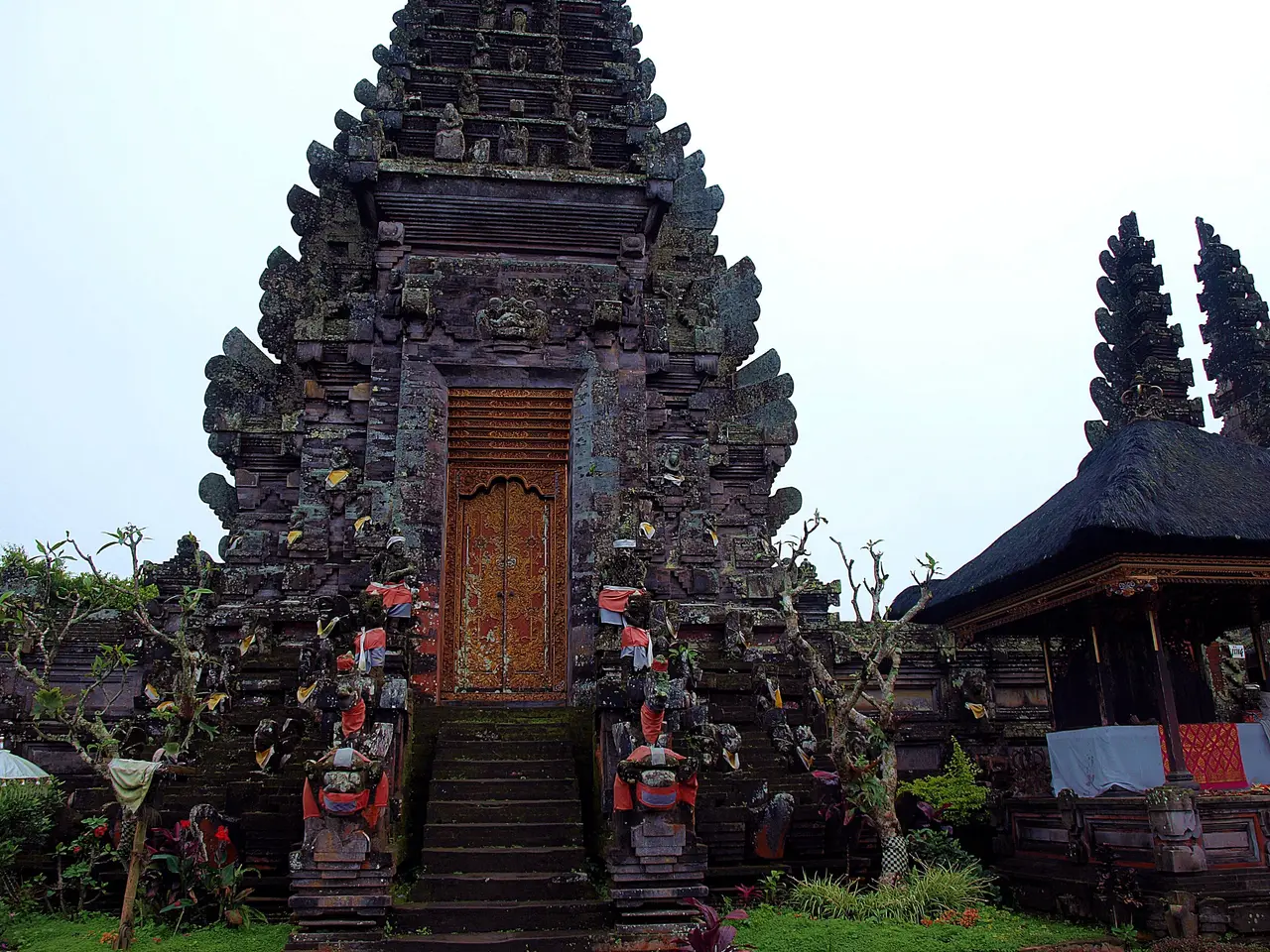 A carved stone gateway at Pura Ulun Danu Batur, with guardian figures at its steps.