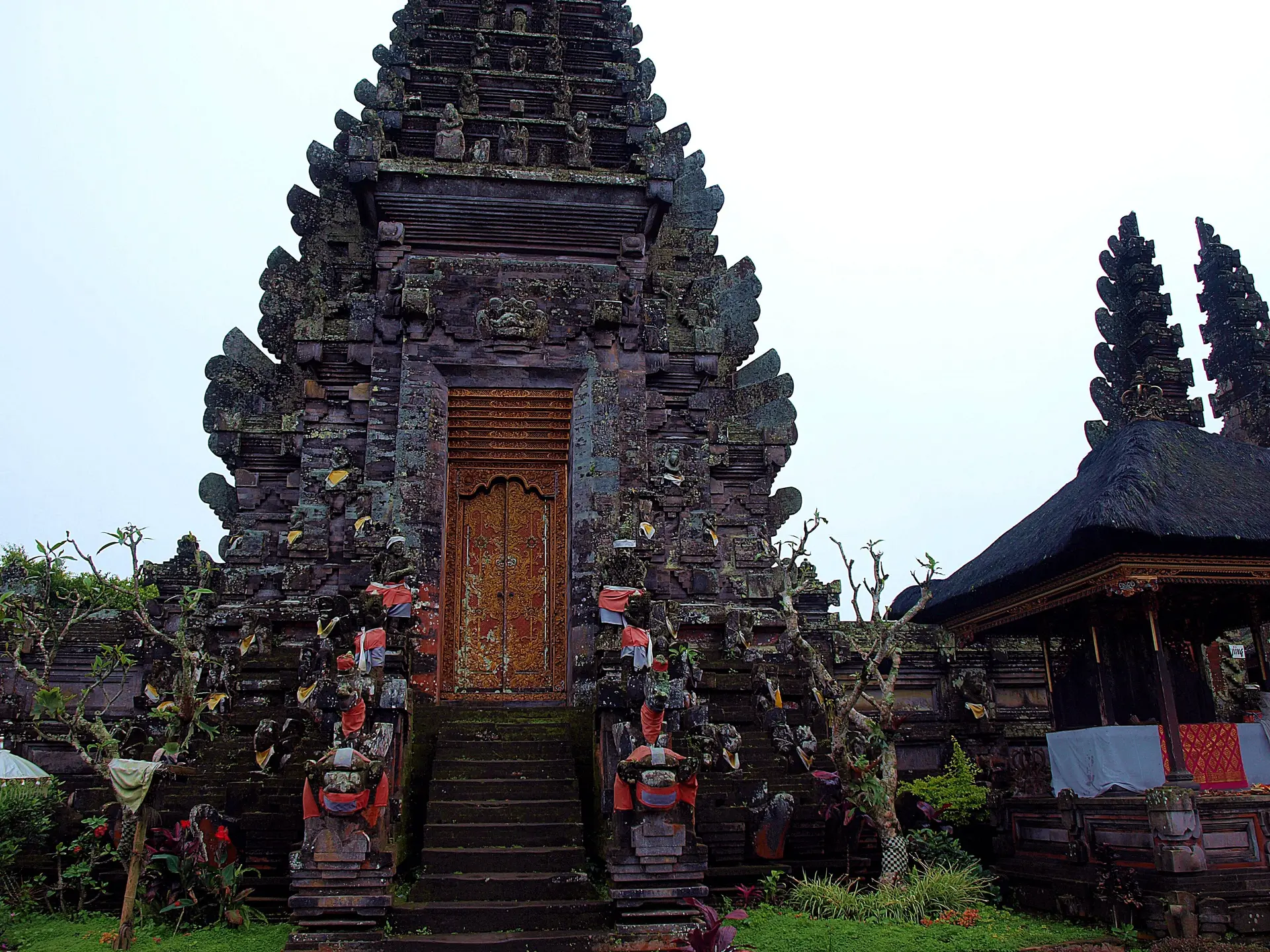 A carved stone gateway at Pura Ulun Danu Batur, with guardian figures at its steps.
