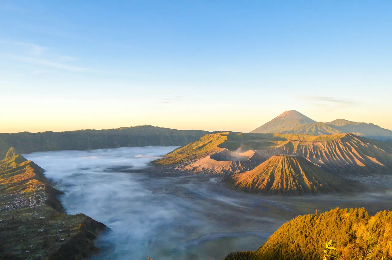 Sunrise over the Tengger caldera in East Java, a sea of fog filling the basin around the cone of Mount Bromo.